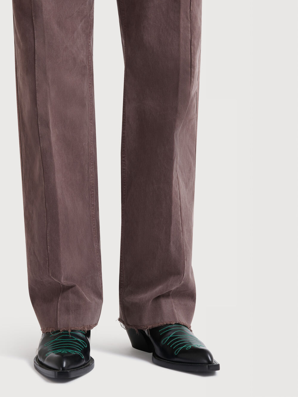 Mannequin portant des bottines en cuir &agrave; bout pointu avec un pantalon marron &agrave; la coupe sartoriale