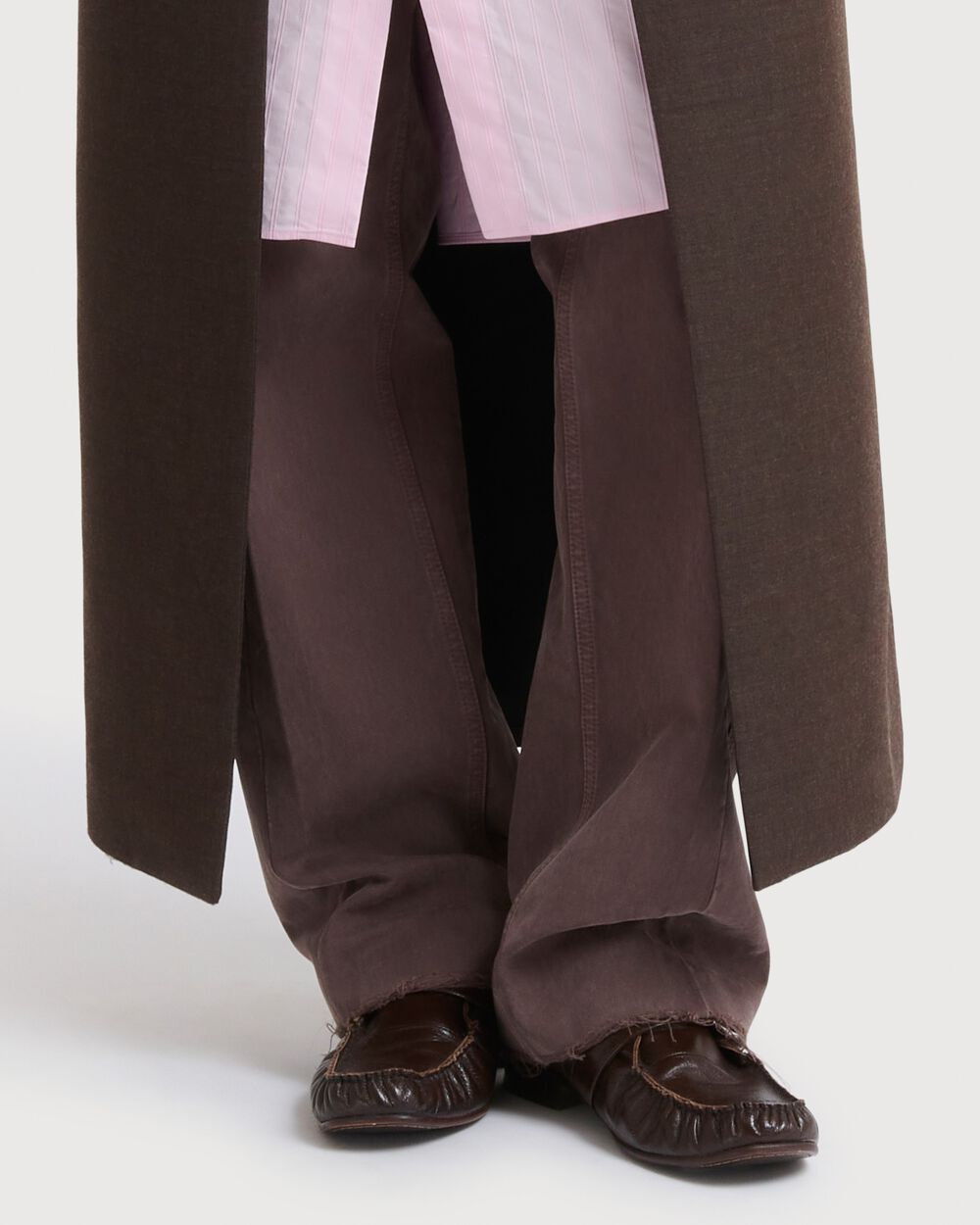 Model wearing brown Marni leather loafers with relaxed brown trousers