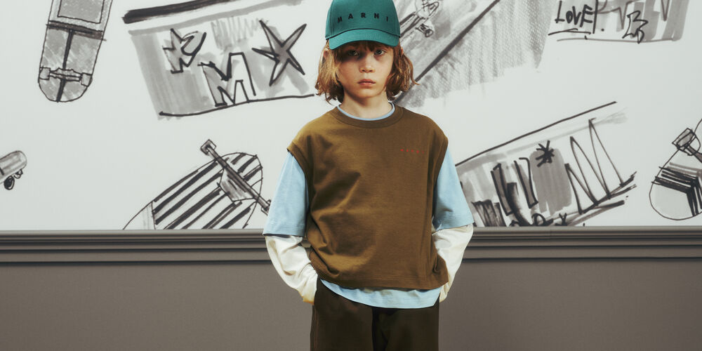 レイヤードしたMarni Kidsのコーディネートにロゴキャップを合わせた子ども