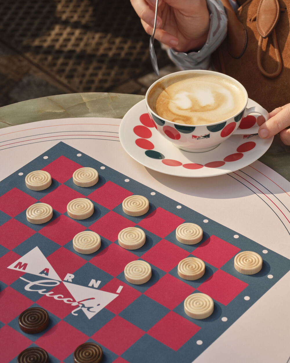 Marni Cucchi checkers board next to a cappuccino cup