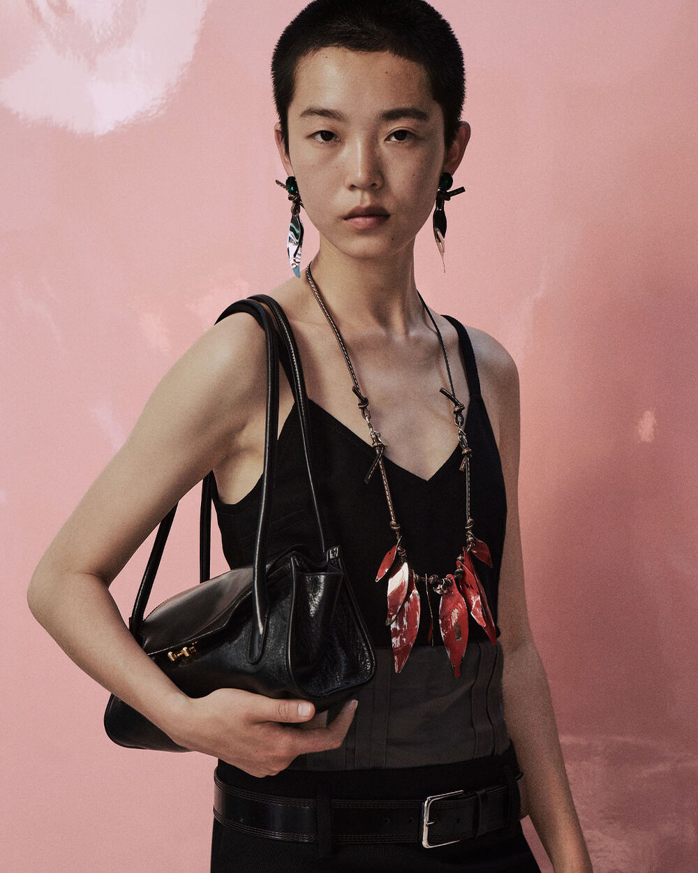 Model wearing a black Marni dress and carrying a black Trunkette bag